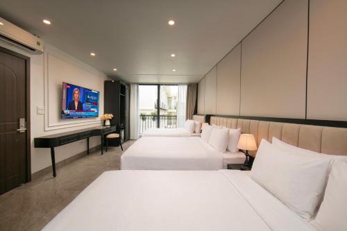 a hotel room with two beds and a desk at Euphoria Hotel & Spa in Hanoi