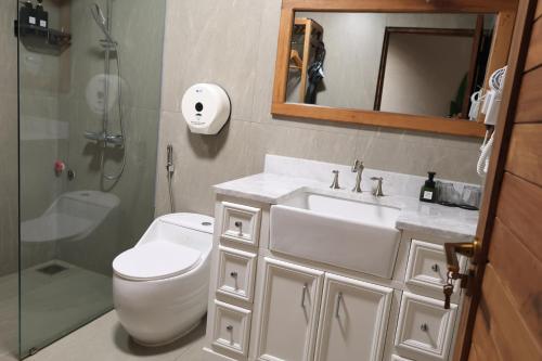 a bathroom with a toilet and a sink and a shower at An Hải Beachfront Retreat Ninh Thuận in Thôn Dư Khánh
