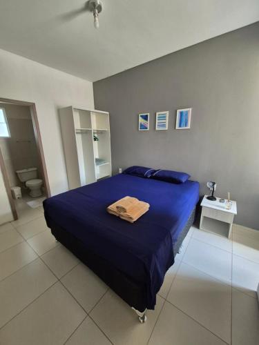 a bedroom with a blue bed and a bathroom at Cumbuco Residence #203 in Caucaia