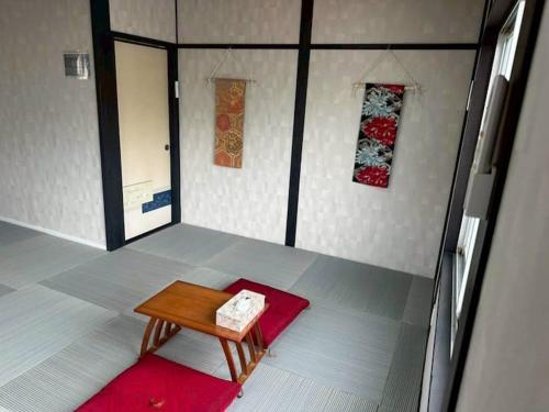 a room with a wooden table and a red rug at Folk-ish Style 風 in Miyazu