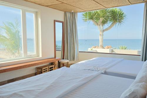 a bedroom with two beds and a view of the ocean at An Hải Beachfront Retreat Ninh Thuận in Thôn Dư Khánh