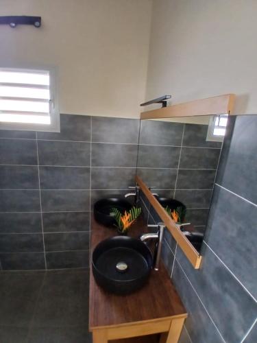a bathroom with a black toilet on a wooden counter at Sun House in Grand-Bourg