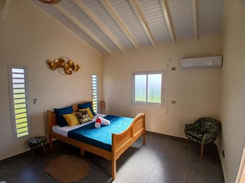 a bedroom with a bed in a room with windows at Sun House in Grand-Bourg