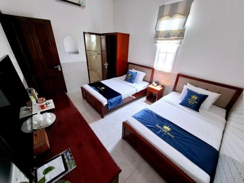 a hotel room with two beds and a window at Tran Vinh Hotel in Bạc Liêu