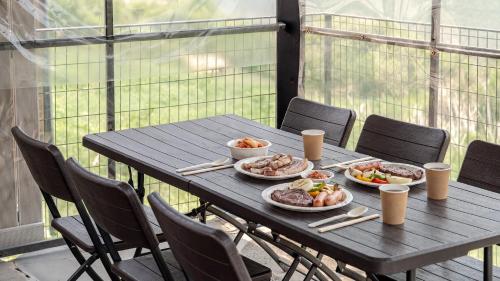 a wooden table with plates of food on it at Hongcheon Around River Poolvilla Pension in Mangdani