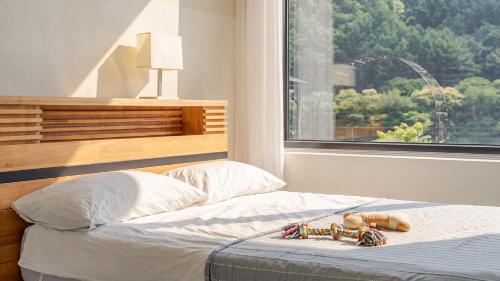 a teddy bear laying on a bed in a bedroom at Hongcheon Around River Poolvilla Pension in Mangdani