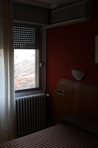 Ένα ή περισσότερα κρεβάτια σε δωμάτιο στο Hostal Cataluña