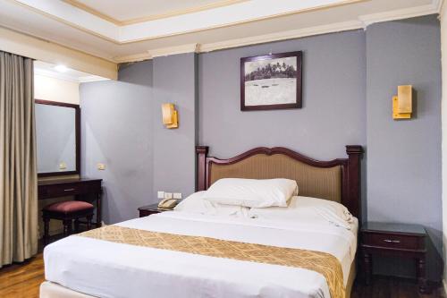 a hotel room with two beds and a mirror at SNUZ Hotel Menteng in Jakarta