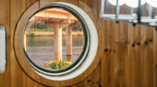 a round window in a wooden wall with a reflection of a bridge at Chuncheon Remember Pet Pension in Chuncheon