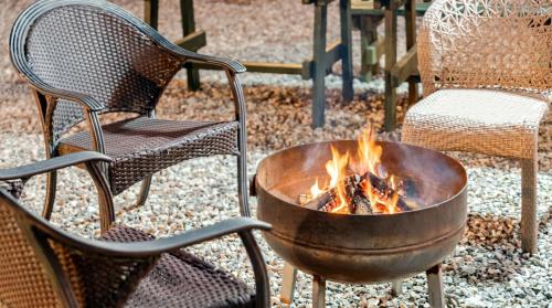 a fire pit sitting next to two chairs and a table at Chuncheon Remember Pet Pension in Chuncheon