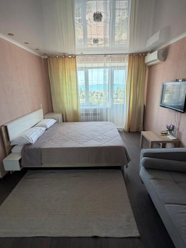 a bedroom with a large bed and a window at Квартира ЛЮКС in Balqash