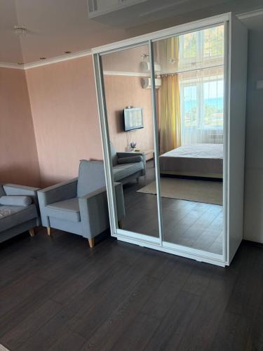 a room with a mirror and a bedroom with a bed at Квартира ЛЮКС in Balqash