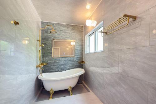 a bathroom with a bath tub and a window at 富士見莊sl0582 in Oshino