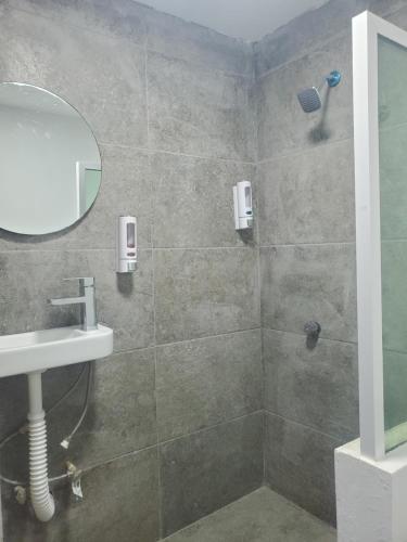 a bathroom with a shower with a sink and a mirror at Lacosta Josss in Acapulco