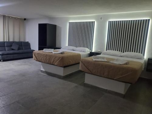 a room with two beds and a couch in a room at Lacosta Josss in Acapulco