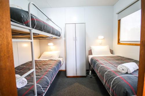 two beds in a small room with a bunk bed at Horsham Holiday Park in Horsham