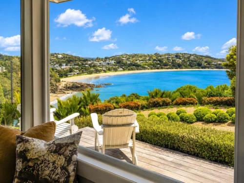 a room with a window with a view of a beach at Smiths Cottage - Stay Waiheke in Oneroa