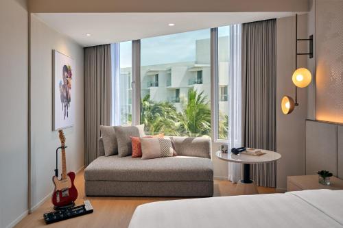 a hotel room with a couch and a large window at Hard Rock Hotel Pattaya in Pattaya