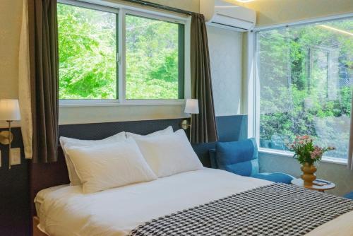a bedroom with a bed and two windows at 富士見莊sl0582 in Oshino