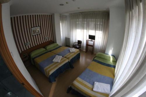 Ένα ή περισσότερα κρεβάτια σε δωμάτιο στο Hostal Cataluña