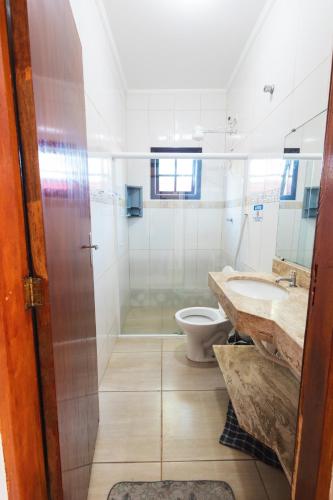 a bathroom with a shower and a toilet and a sink at Sinuca, churrasqueira e fogueira a 300 metros do mar in Itanhaém