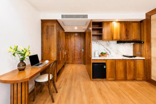 a kitchen with a desk and a laptop on a table at Mixay Boutique Hotel Da Nang in Danang