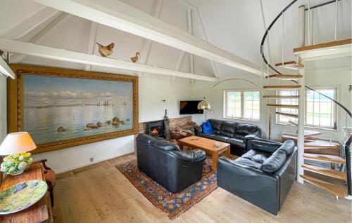 a living room with leather furniture and a fireplace at Beautiful Home In Øster Ulslev With Wifi in Øster Ulslev