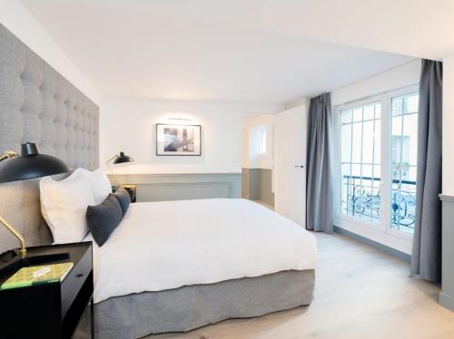 a bedroom with a large white bed and a window at Amseltim in Madrid