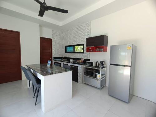 a kitchen with a stainless steel refrigerator and a counter at Lamai Sunshine Villas in Hua Thanon Beach