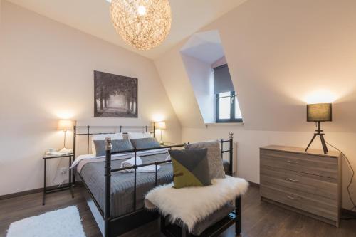 a bedroom with a bed and a chair and a chandelier at 7 Koron - Exclusive Apartments in Kraków