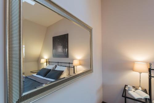 a mirror hanging on a wall in a bedroom at 7 Koron - Exclusive Apartments in Kraków