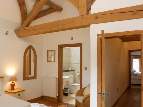 a room with a bed and a bathroom at The Hay Barn in Halwell