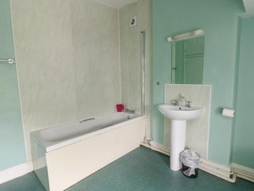 a bathroom with a bath tub and a sink at Halford Hill in Llanberis