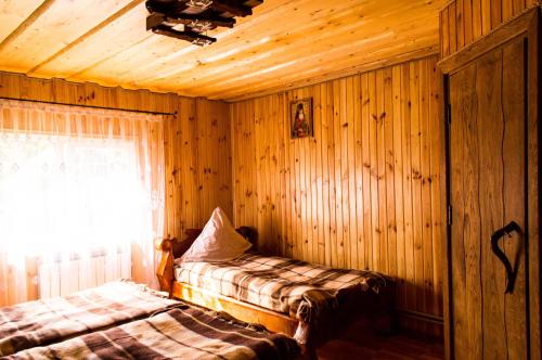 a bedroom with wood paneling and a bed and a window at Synevyrskyj Chardash in Synevyr
