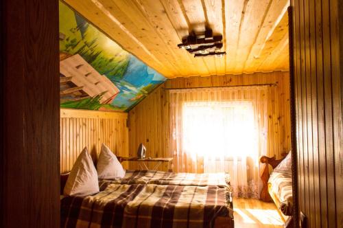 a bedroom with a bed in a room with a ceiling at Synevyrskyj Chardash in Synevyr
