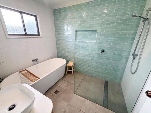 a bathroom with a tub and a toilet and a sink at Arcos in Hat Head