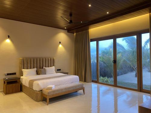 a bedroom with a bed and a large window at Beach Escape in Arugam Bay