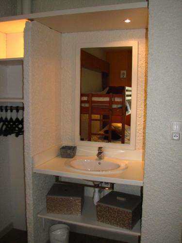 une salle de bain avec un lavabo et un miroir dans l'établissement VVF Bourgogne Auxois Morvan, à Semur-en-Auxois