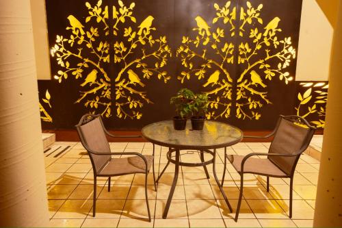 a table and chairs in a room with a wall at HOTEL NIUT-JA in Oaxaca City