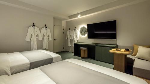 a hotel room with two beds and a flat screen tv at Anook Hotel Ulsan Samsan in Ulsan
