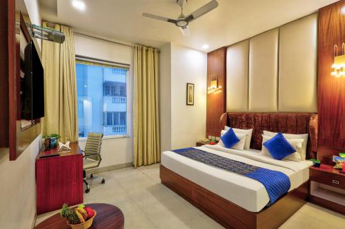 a hotel room with a bed and a television at Hotel Royal Imporio Surajkund Faridabad in Faridabad