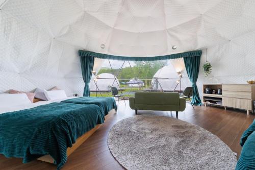 a bedroom with a bed and a couch and a table at GRAMPING STAY TOMAMU in Tomamu