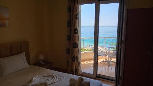 a bedroom with a bed and a view of the ocean at Magic Ionian Apartments & Rooms in Himare