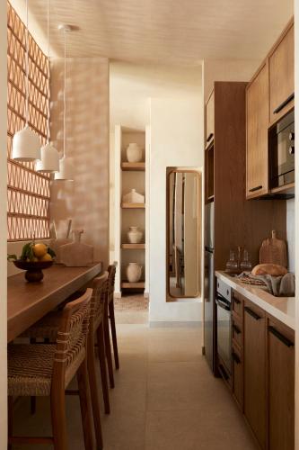 a kitchen with a table and chairs and a refrigerator at Memorias Villas and Suites in Vasilikos