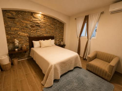 a bedroom with a bed and a chair at Hotel Bugambilia in Zimapán