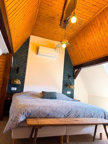 a bedroom with a bed with a wooden ceiling at Cottage des potiers in Niederbetschdorf