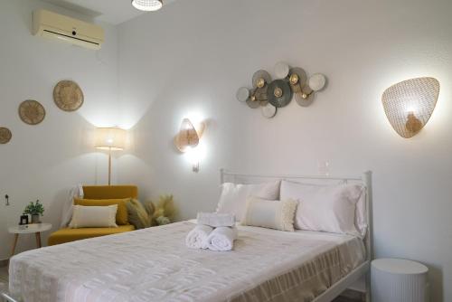 a bedroom with a white bed with towels on it at Studios Margarita in Artemonas
