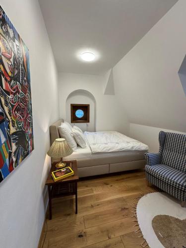 a bedroom with a bed and a chair and a table at Apartmán - Ostrůvek 203 in Lesná