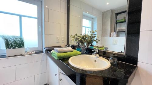 a bathroom with a sink and a mirror at Strandbox & Strandresidenz in Norderney