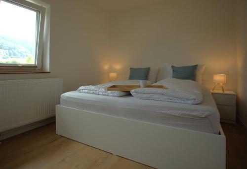 a white bed in a room with a window at Trüffelhof 2 in Bodman-Ludwigshafen